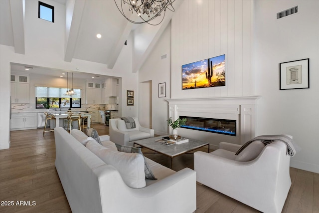 3808 E Fairmount Ave, Phoenix, AZ 85018 - living room with high vaulted ceiling, wood finished floors, a chandelier, and a glass covered fireplace