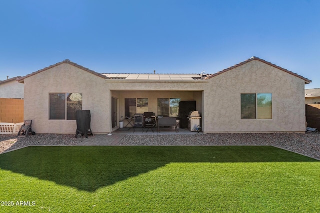 rear view of house featuring a lawn and a patio area