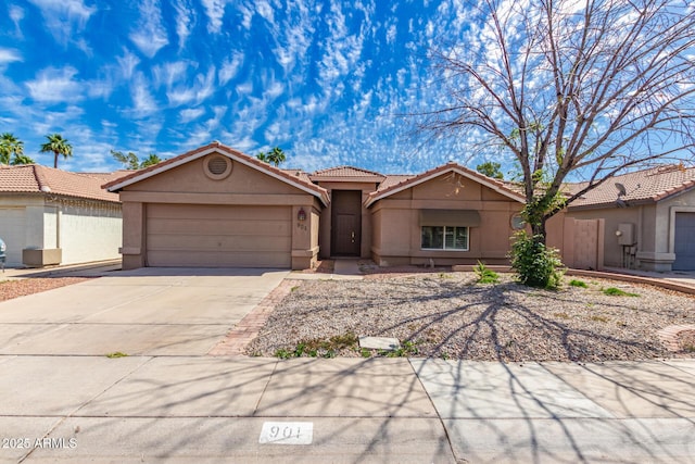 ranch-style house with concrete driveway, a garage, a tile roof, and stucco siding