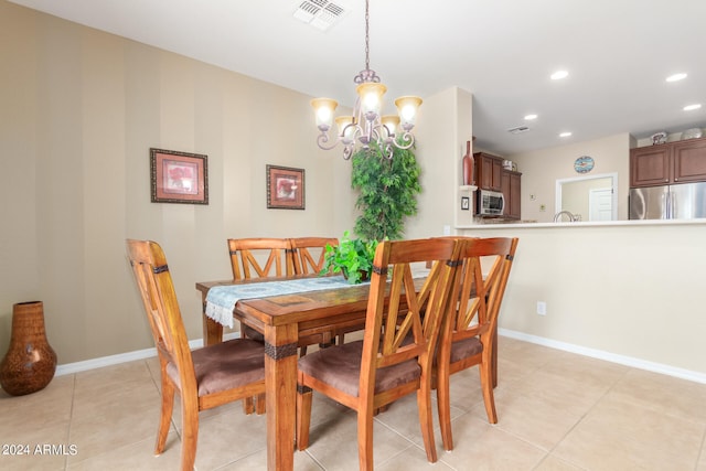 dining area with light tile patterned floors and an inviting chandelier