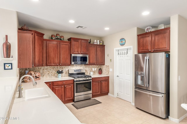 kitchen featuring appliances with stainless steel finishes, light tile patterned floors, sink, and backsplash