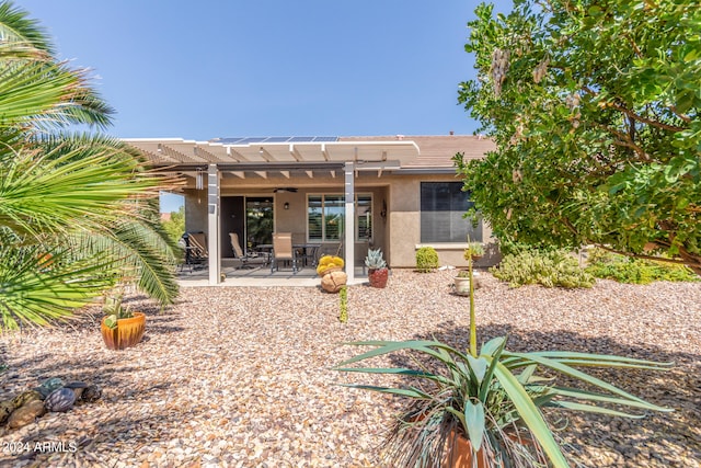 rear view of house with ceiling fan, a patio, and a pergola