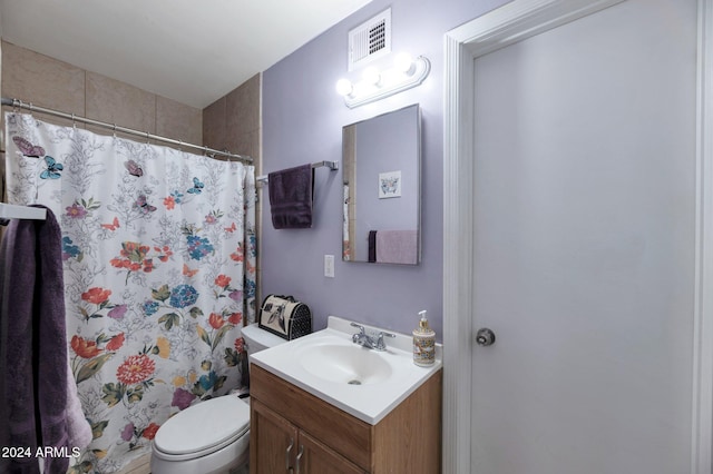 bathroom featuring curtained shower, vanity, and toilet