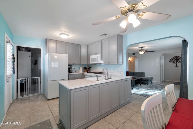 kitchen with white appliances, ceiling fan, kitchen peninsula, and gray cabinets