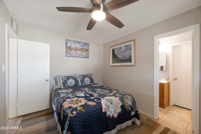 bedroom featuring ensuite bathroom, ceiling fan, and light tile patterned flooring