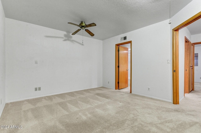 carpeted empty room featuring ceiling fan and a textured ceiling