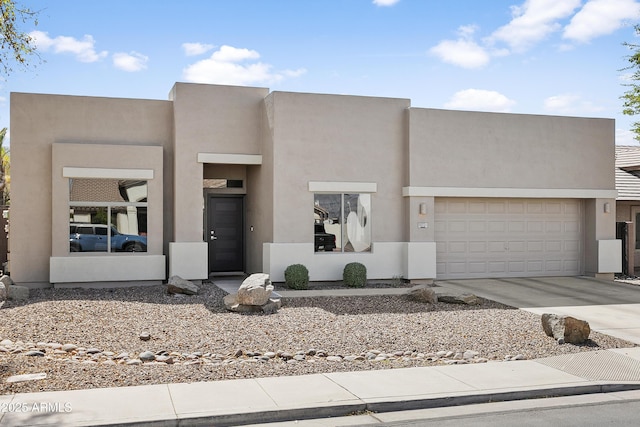 view of front of property with stucco siding, a garage, and concrete driveway