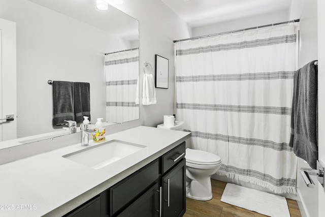 bathroom with curtained shower, toilet, vanity, and wood finished floors