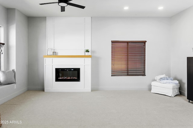 carpeted living area featuring a ceiling fan, recessed lighting, a fireplace, and baseboards