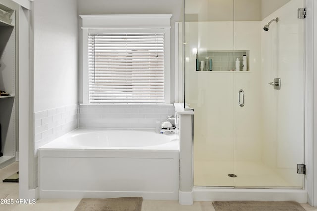 full bathroom featuring a bath and a shower stall