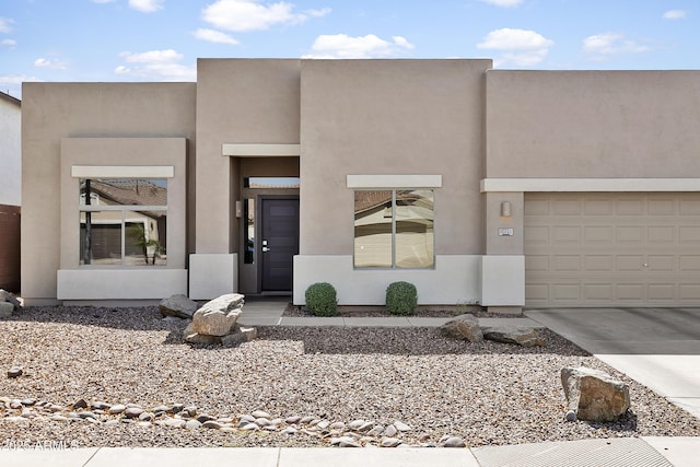 view of front of home with stucco siding and concrete driveway