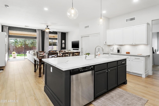 kitchen featuring visible vents, dishwasher, white cabinets, and decorative backsplash