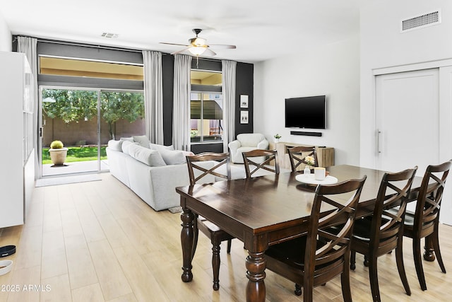 dining area with visible vents, light wood-style floors, and ceiling fan