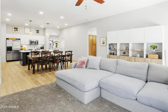 living area with recessed lighting, baseboards, light wood-type flooring, and a ceiling fan