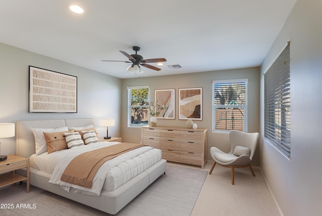 carpeted bedroom with multiple windows and ceiling fan