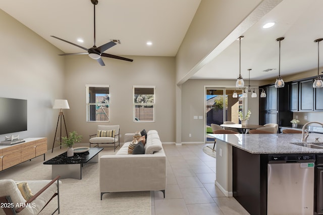 living room with plenty of natural light, sink, light tile patterned floors, and ceiling fan