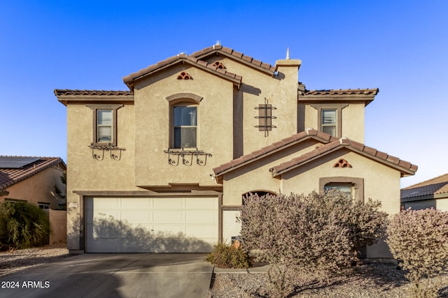 mediterranean / spanish-style house with a garage