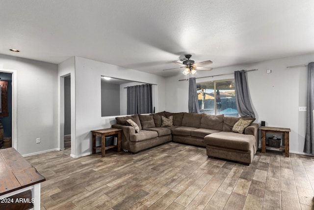 living room featuring a textured ceiling, hardwood / wood-style flooring, and ceiling fan