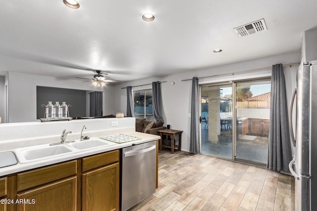 kitchen with ceiling fan, sink, stainless steel appliances, and light hardwood / wood-style floors