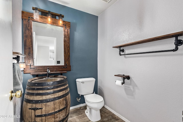 bathroom with toilet, vanity, and hardwood / wood-style flooring