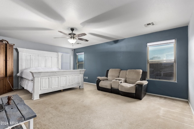 bedroom with light carpet, a textured ceiling, and ceiling fan