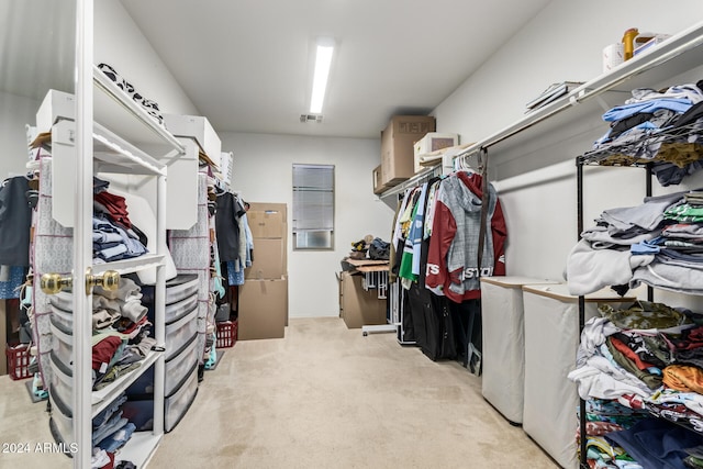 walk in closet featuring light colored carpet