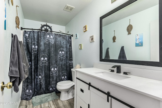 bathroom featuring vanity, wood-type flooring, and toilet