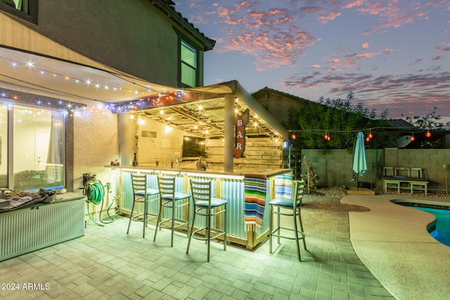 patio terrace at dusk featuring exterior bar