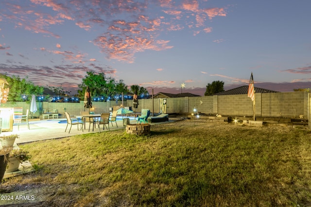 yard at dusk featuring a patio area