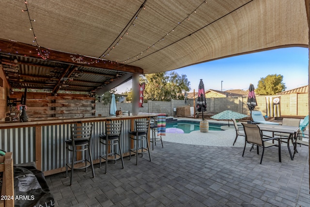 view of patio featuring a fenced in pool and a bar