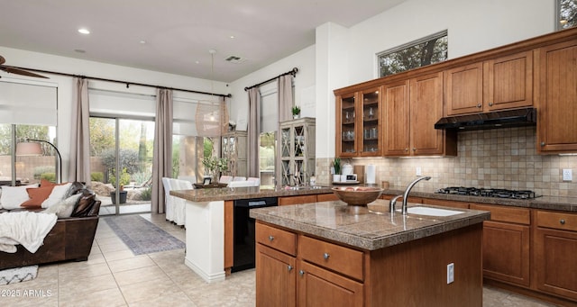 kitchen with decorative backsplash, gas stovetop, black dishwasher, and an island with sink