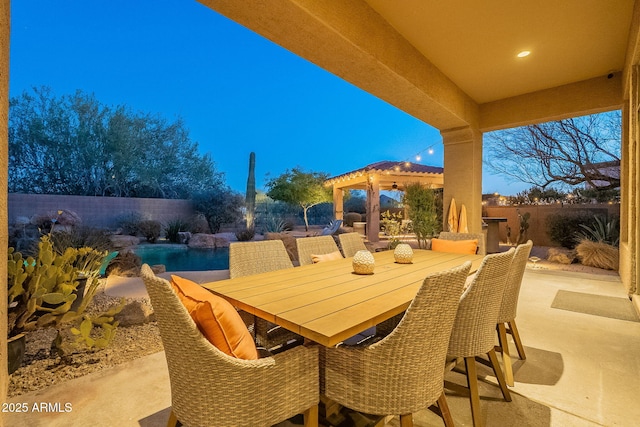 patio terrace at dusk featuring a fenced in pool