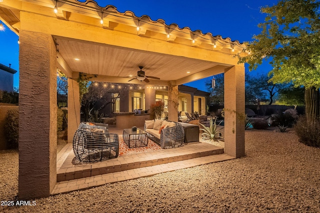 patio at twilight with an outdoor living space and ceiling fan