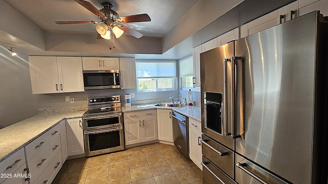 5751 W Muriel Dr, Glendale, AZ 85308 - kitchen featuring stainless steel appliances, white cabinets, ceiling fan, light tile patterned floors, and light stone countertops