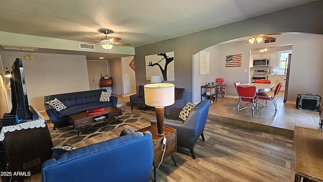 5751 W Muriel Dr, Glendale, AZ 85308 - living room with arched walkways, ceiling fan, and wood finished floors