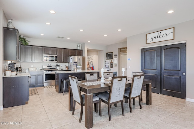 dining area featuring sink and light tile patterned floors