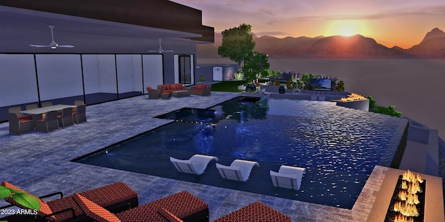 pool at dusk featuring a patio area, ceiling fan, a water and mountain view, and an outdoor living space