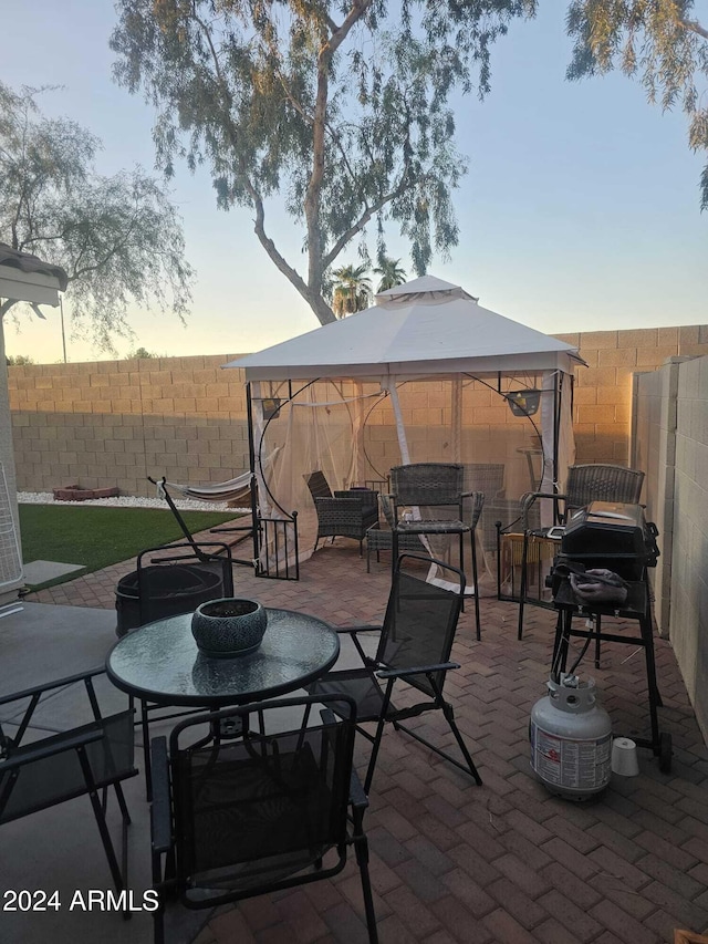 patio terrace at dusk featuring a gazebo