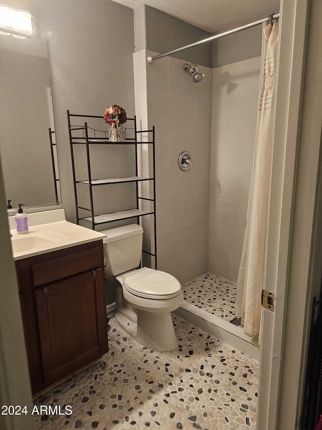 bathroom featuring walk in shower, vanity, toilet, and tile patterned floors