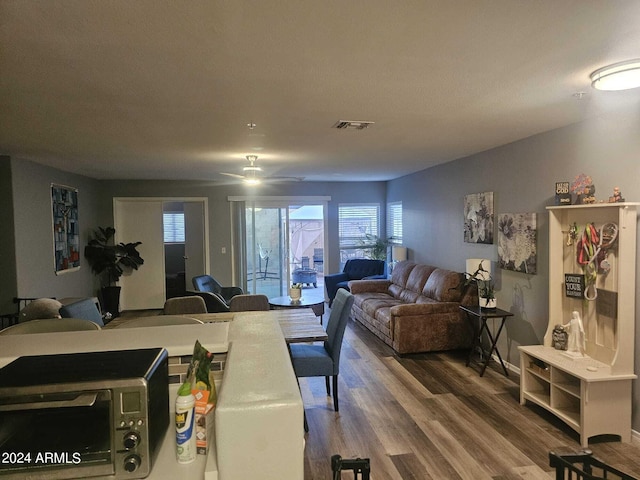 living room featuring ceiling fan and hardwood / wood-style flooring