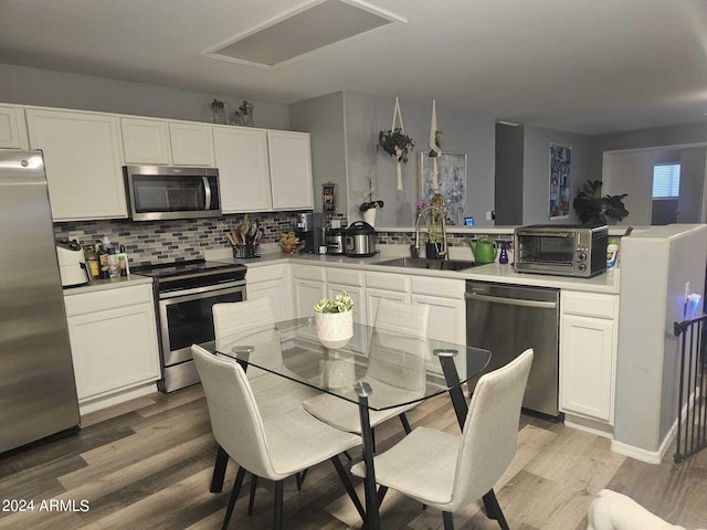 kitchen with stainless steel appliances, white cabinets, and sink