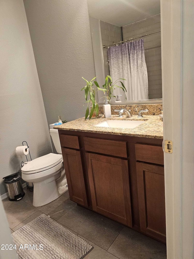 bathroom with tile patterned floors, walk in shower, vanity, and toilet