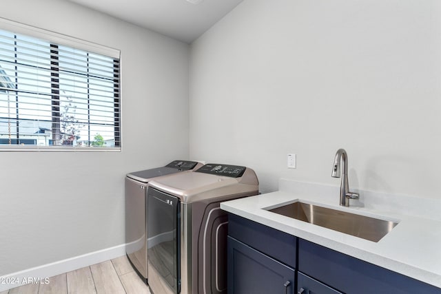 washroom featuring sink, cabinets, and washer and dryer