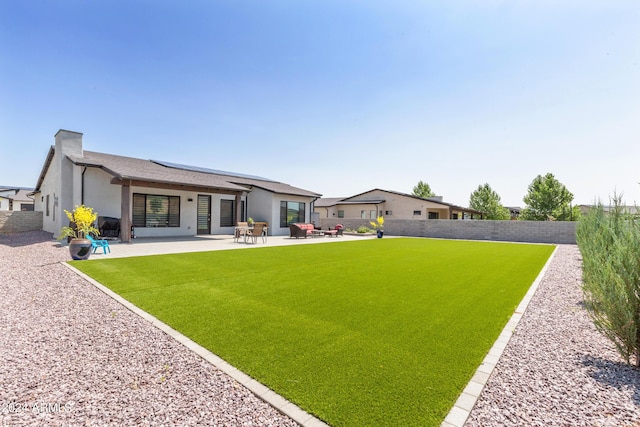 back of property featuring a patio area and a yard