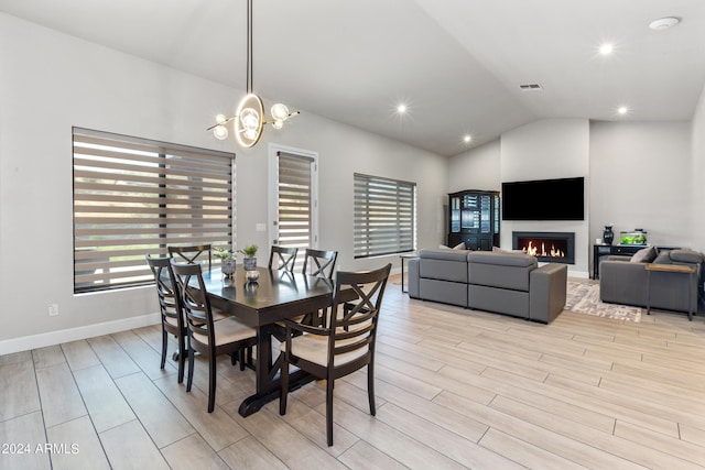 dining room featuring vaulted ceiling and an inviting chandelier