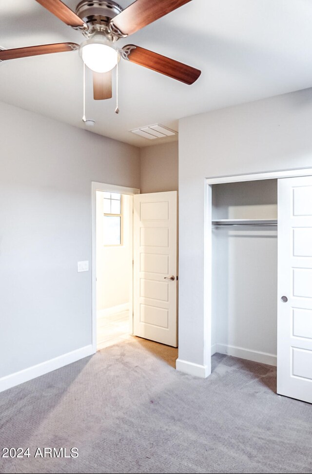 unfurnished bedroom with light carpet, a closet, and ceiling fan