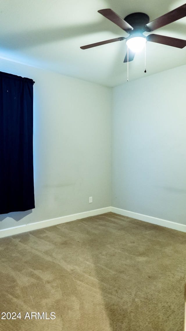 empty room featuring carpet flooring and ceiling fan