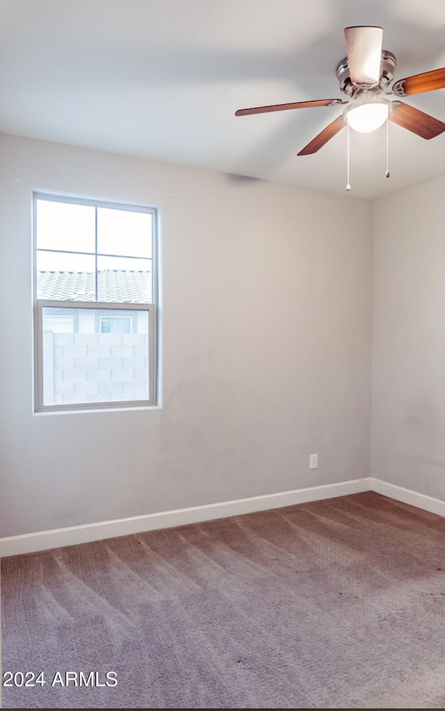 empty room featuring ceiling fan and carpet flooring