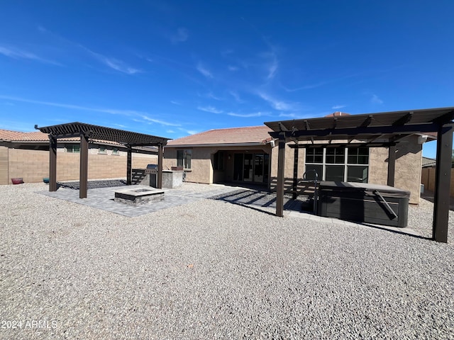 rear view of property with a patio, a hot tub, and a pergola