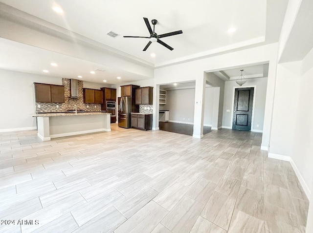 unfurnished living room with sink and ceiling fan